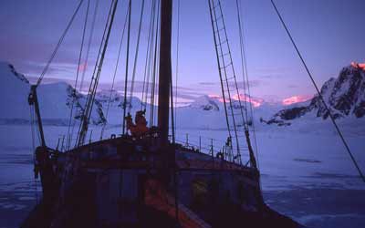 a view of mountains in front of the ship at dawn